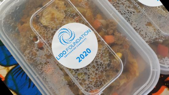 Plastic container containing cultural food with Lido Foundation branding on the lid